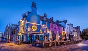 Fachada exterior del pub Mash Tun en Brighton al atardecer con iluminación cálida