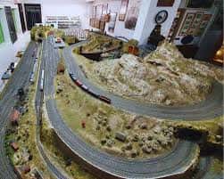 Maqueta detallada de un ferrocarril con vías curvas y paisaje montañoso