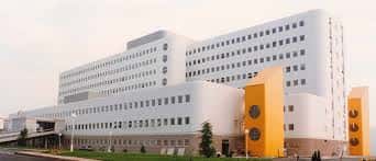 Fachada principal del Hospital Meixoeiro con detalles arquitectónicos en blanco y amarillo