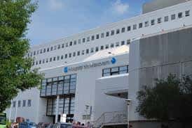 Entrada del Hospital Meixoeiro con señalización y árboles alrededor