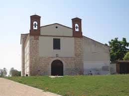 Vista exterior de la Ermita de San Isidro en Valladolid con fachada de piedra y campanarios