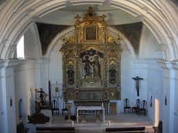 Interior de la Ermita de San Isidro con retablo dorado y altar principal