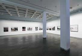 Espacio expositivo amplio con paredes blancas y fotografías enmarcadas