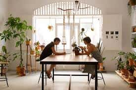 Interior de Biznaga Atelier con dos personas trabajando en una mesa rodeada de plantas