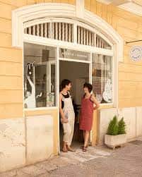 Fachada exterior de Biznaga Atelier con dos personas conversando en la entrada