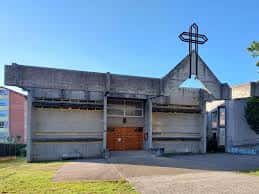 Vista exterior de la Parroquia Cristo Rey en Ourense con su distintiva cruz y arquitectura brutalista