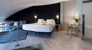 Suite con cama central, zona de estar y diseño contemporáneo