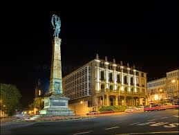 Plaza de Galicia en Ferrol iluminada por la noche con el monumento central