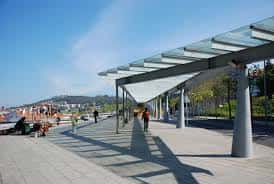 Plaza peatonal de la Dársena con personas caminando y sombra proyectada por el techo moderno