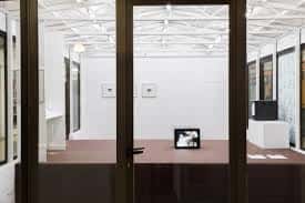 Vista del interior del espacio de arte a través de una puerta de cristal