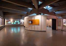 Interior del museo con estructura de vigas de hormigón y espacios expositivos amplios