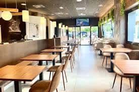 Interior del restaurante Aveniu con mesas dispuestas y decoración moderna