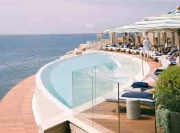 Piscina infinita del Lobster Club con vistas al mar y tumbonas