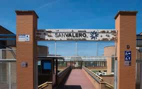 Acceso principal al campus del Grupo San Valero con letrero institucional y pasarela peatonal