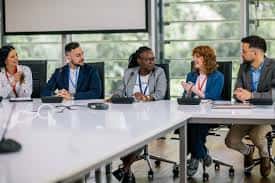 Grupo de profesionales reunidos en una sala de conferencias moderna con mesa larga y ventanales