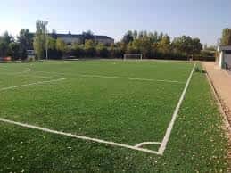 Vista exterior del campo de fútbol Don Bosco en Valladolid con césped artificial y líneas blancas marcadas