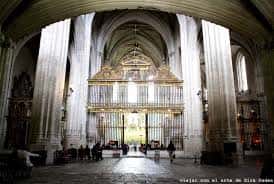 Interior de la iglesia con gran órgano dorado y columnas de estilo gótico