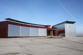 Vista exterior del Bioparc Acuario de Gijón con arquitectura moderna bajo cielo despejado