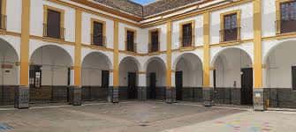 Patio central del colegio con arquerías y detalles arquitectónicos sin personas