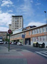 Vista exterior del Centro Cívico Otxarkoaga con fachada de ladrillo y cielo azul