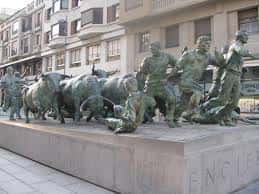 Vista general del Monumento al Encierro en Pamplona, mostrando las estatuas de bronce de los corredores y los toros en movimiento