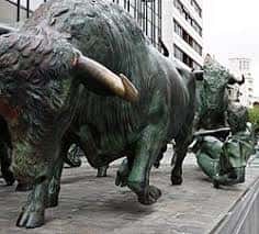 Primer plano de los toros de bronce en el monumento, capturando el detalle de sus cuernos y musculatura