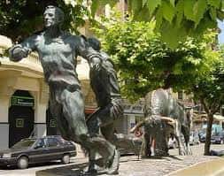 Detalle de un corredor en el monumento, con árboles y entorno urbano al fondo