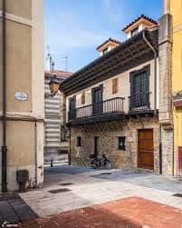Fachada exterior del Palacio Alvargonzález en Gijón con balcones de hierro y detalles arquitectónicos del siglo XVIII