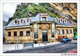 Vista frontal del edificio de la Sociedad Fotográfica con fondo rocoso