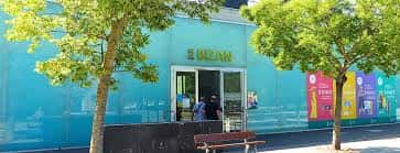 Fachada exterior del centro cultural BIZAN Ariznabarra con paredes azules y entrada principal