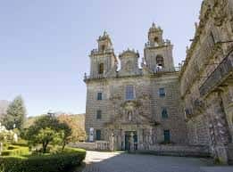 Fachada principal del monasterio con torres y jardines delanteros