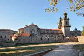 Vista lateral del monasterio con la iglesia y el campanario bajo el cielo azul
