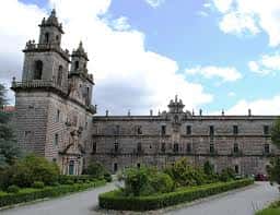 Plaza frontal del monasterio con acceso principal y vegetación cuidada