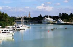 Vista panorámica del Muelle de las Delicias con barcos atracados y el Torreón del Almirante al fondo