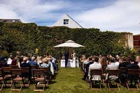 Ceremonia de boda al aire libre en el jardín con invitados sentados