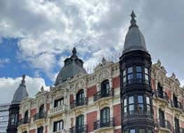 Detalle de la torre y cornisa del edificio con cielo nublado