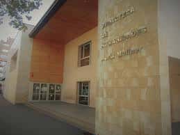 Vista exterior de la Biblioteca de Humanidades María Moliner con fachada de piedra y madera