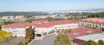 Vista aérea del campus del Colegio Obradoiro con edificios de tejados rojos y canchas deportivas
