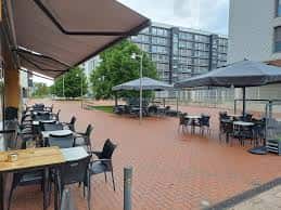 Terraza exterior de Bar Brown 46 con mesas y sombrillas