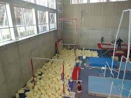 Zona de entrenamiento de gimnasia con colchonetas y obstáculos en el interior del polideportivo
