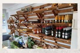 Interior del Ekonomato Arabarazki mostrando estanterías de madera con productos locales y frescos