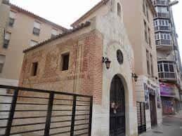 Fachada lateral de la capilla mostrando detalles arquitectónicos y entorno urbano