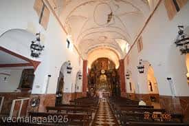 Interior de la nave central de la iglesia con bóvedas y bancos de madera