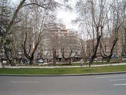 Vista general de la plaza con árboles, zonas verdes y edificios residenciales al fondo en Valladolid