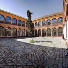 Patio interior de la Escuela Superior de Arte Dramático con arquitectura de arcos y escultura central
