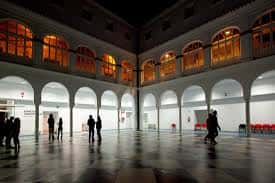 Interior del patio principal del CICUS con arcos iluminados y suelo reflectante