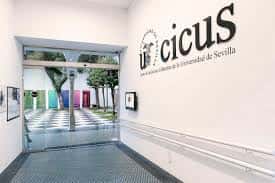 Entrada moderna del CICUS con logotipo de la Universidad de Sevilla en la pared