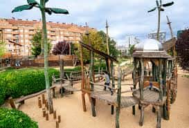 Área de juegos infantil con pasarelas y torres de madera en el parque