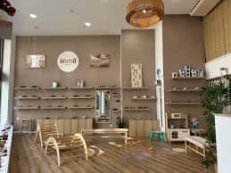 Interior de la tienda Ánima Barefoot con estanterías de madera y zona de descanso