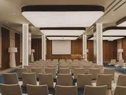Sala de conferencias con proyector y disposición en teatro